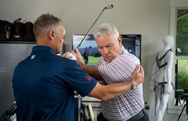 man getting golf lessons